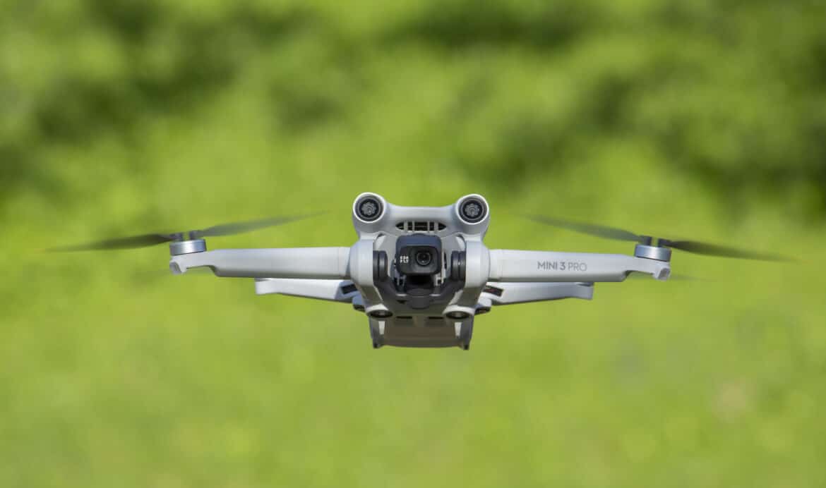IASI, ROMANIA – MAY 21 2022: DJI Mini 3 Pro drone flying with green background